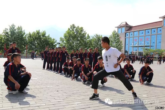 嵩山少林寺武僧团培训基地教练员正在给学员示范标准的武术动作